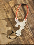 Plastic Slingshot Unique Shape With Red Elastic Band White Frame. Fixed Price $40.00.